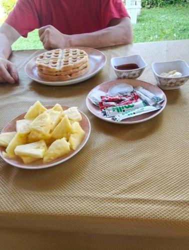 ein Tisch mit drei Tellern mit Essen und Waffeln und Waffel in der Unterkunft Paradise Beach Appart with Kitchen by Casa in Kribi