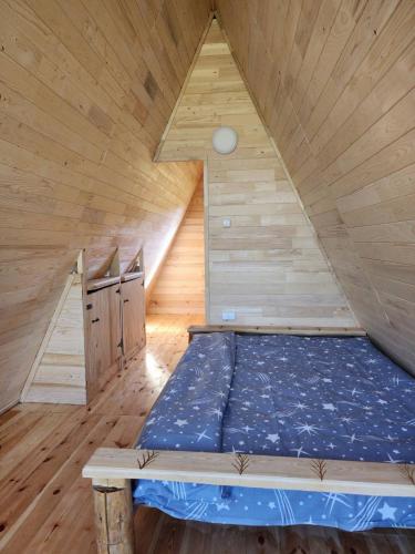 a bed in a room with a wooden ceiling at Etno SELO Uskoci in Uskoci