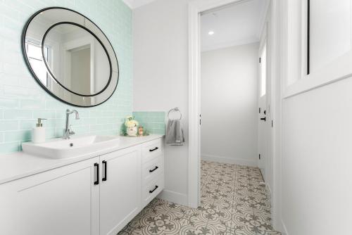 a bathroom with a sink and a mirror at Hamptons On Dux Retreat in Banksia Beach
