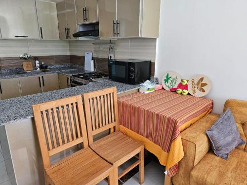 a kitchen with a table and two chairs and a couch at شاليه جديد في مارينا دلتا لاجونز in Balṭîm