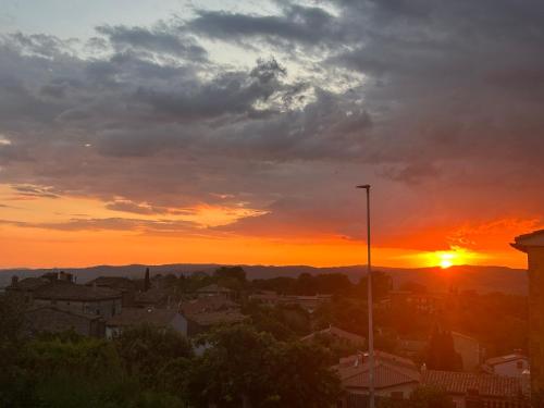 a sunset over a city with the sun setting at Saturnia Residence in Poggio Murella