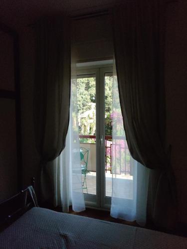 a bedroom with a bed and a sliding glass door at Quintadecima Rooms in Palermo