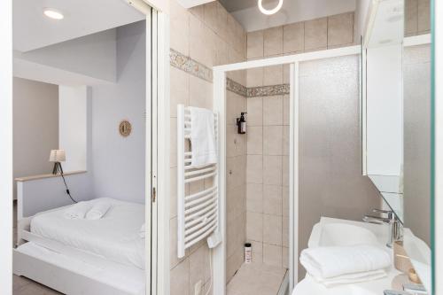 La salle de bains est pourvue d'une douche, d'un lit et d'un miroir. dans l'établissement Charmante maison - Proche Monaco - Piscine partagée - DP, à Beausoleil