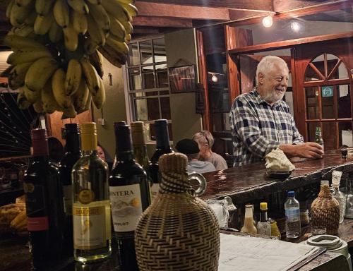 a man standing at a bar with bottles of wine at Hibiscus Valley Inn in Marigot