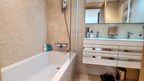 une salle de bain avec une baignoire, un lavabo et une douche dans l'établissement Bright 2-Bedroom apartment with terrace & parking, à Cannes