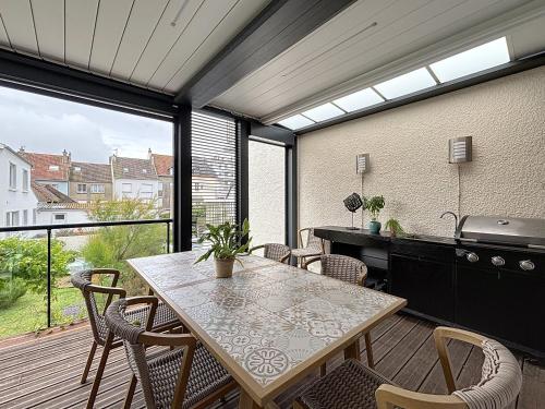 une cuisine et une salle à manger avec une table et des chaises dans l'établissement La Crevette, à Wimereux