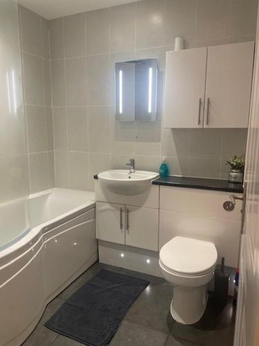 a white bathroom with a toilet and a sink at Number One - Inglewood in Parkstone