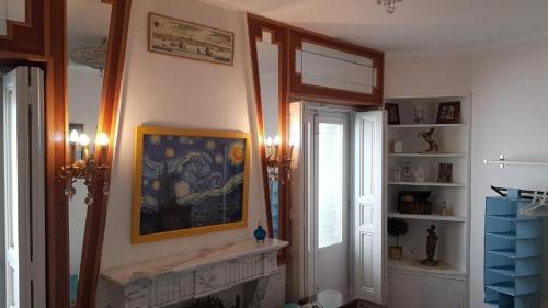 a living room with a fireplace and a painting on the wall at Habitaciones en Luisa in Madrid