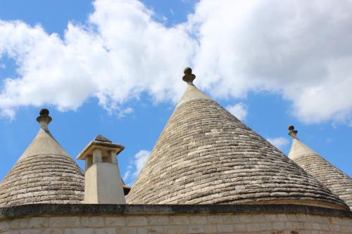two tiled roofs of a building with the sky in the background at Trulli Gemma in Antonelli