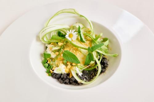 a white bowl with a salad with greens and onions at Castello Di Postignano Relais in Sellano
