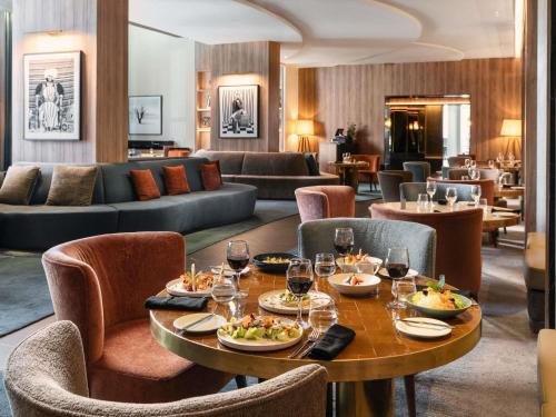 a restaurant with a table with food and wine glasses at Sofitel Casablanca Tour Blanche in Casablanca