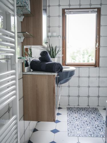 une salle de bain avec un lavabo, un miroir et une fenêtre dans l'établissement Venez Chez Vous La Maison Bleue, à Sévrier