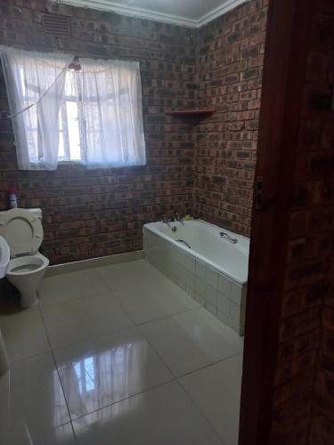 a bathroom with a bath tub and a toilet at TheManqeleEstate in Cleland