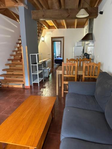 a living room with a blue couch and a table at Casa Rural Bermeja in Soto de Valdeón