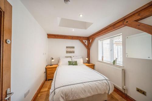 ein Schlafzimmer mit einem Bett und einem Fenster in der Unterkunft 8 Bedroom, 6 Bath House, Large Patio, Large Parking in Hardwicke