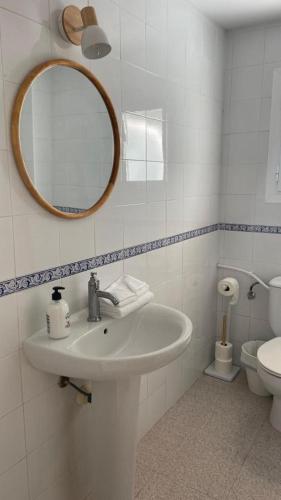a bathroom with a sink and a mirror and a toilet at Ca sa Madona Hostal in Paguera