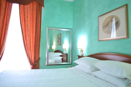 a bedroom with a white bed and a mirror at Guest House Masterintrastevere in Rome