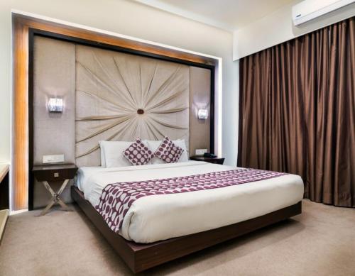 a bedroom with a large bed with a large headboard at Jonny City Hotel in Kumasi