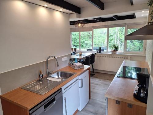 a kitchen with a sink and a counter top at Vrijstaande vakantiebungalow met optimale privacy!! in Rekem