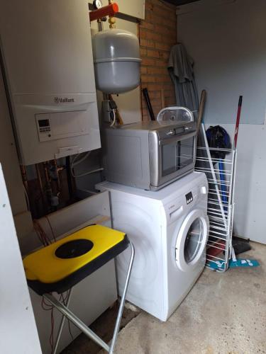 a kitchen with a washing machine and a sink at Vrijstaande vakantiebungalow met optimale privacy!! in Rekem