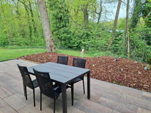 a black table with four chairs sitting on a patio at Vrijstaande vakantiebungalow met optimale privacy!! in Rekem