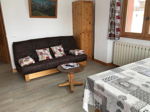 un salon avec un canapé noir et une table dans l'établissement Montana 2, à Pralognan-la-Vanoise
