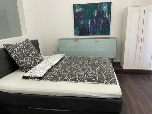 a bed with a black and white comforter and pillows at ARYVE Boutique-Apartments in bester Lage in Bad Hersfeld in Bad Hersfeld