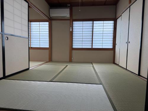 an empty room with white floors and windows at 千田民宿 in Takayama