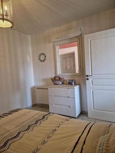 une chambre avec un lit, une commode et un miroir dans l'établissement Appartement 2 P calme, à Cagnes-sur-Mer