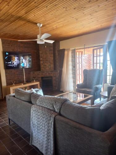 a living room with a couch and a tv at TheManqeleEstate in Cleland
