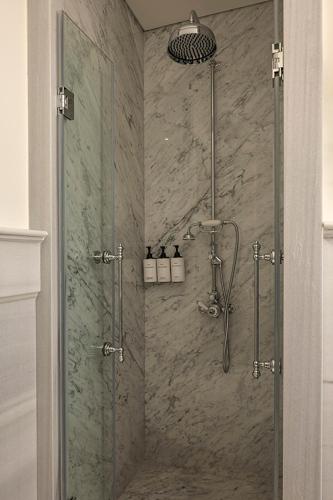 a shower with a glass door in a bathroom at Komana Hotel Binbirdirek in Istanbul