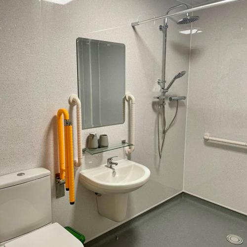 a bathroom with a shower and a toilet and a sink at Corner Post Holiday Letting in Weymouth