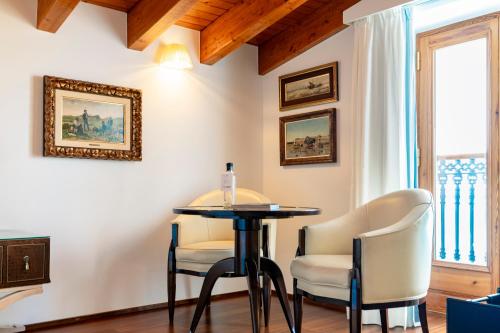 a table and chairs in a room with a window at Mirador de Dalt Vila-Relais & Chateaux in Ibiza Town