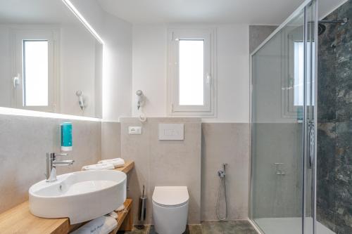 a white bathroom with a sink and a shower at Hotel Mayer in Lido di Jesolo