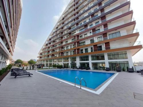 a large building with a swimming pool in front of it at RoyalRest at Signature CPG in Accra