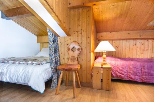 une chambre avec un lit, une chaise et une lampe dans l'établissement chamonix centre le clos du savoy, à La Celle-sous-Gouzon