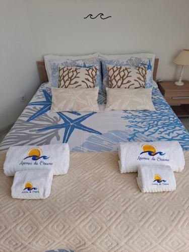 a bedroom with a bed with towels on it at Aromas do Oceano in Nazaré