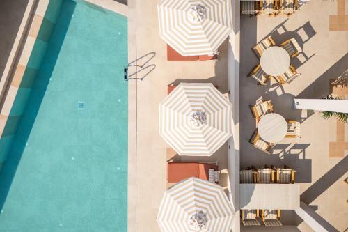 an overhead view of chairs and umbrellas next to a pool at Minnŏ Boutique Hotel & Spa in Skopelos Town