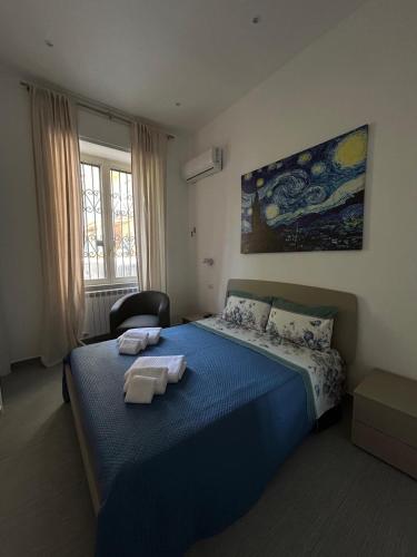 a bedroom with a blue bed with towels on it at Daddy House in San Giorgio a Cremano
