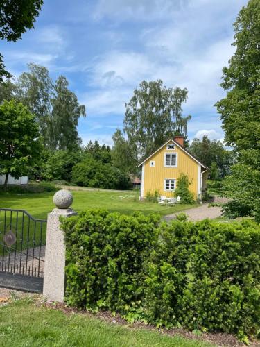 a yellow house in the middle of a yard at Trevligt eget hus med kakelugn i lantlig miljö in Vikingstad