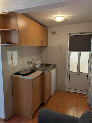 a small kitchen with a sink and a counter at Apartmani Abeona in Budva