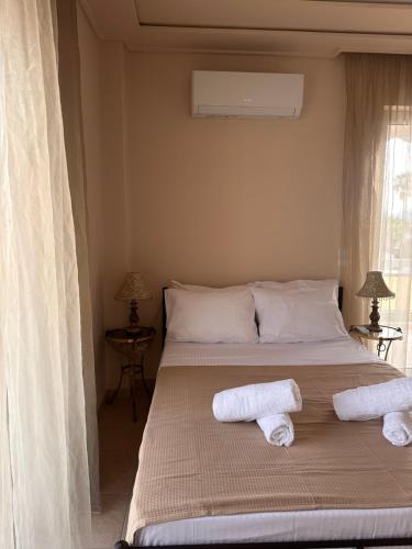a bedroom with a bed with two towels on it at Spacious apartment with top view in Nea Makri