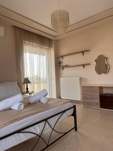 a bedroom with a large bed and a window at Spacious apartment with top view in Nea Makri