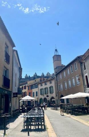 une rue de la ville avec des tables, des chaises et des bâtiments dans l'établissement La Casita Trivala, à Carcassonne