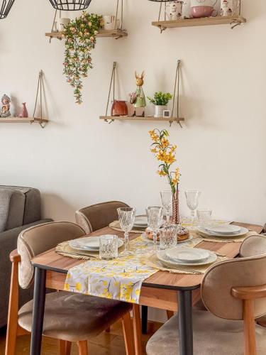 a dining room table with plates and glasses on it at Apartment Vila Jela in Kolašin