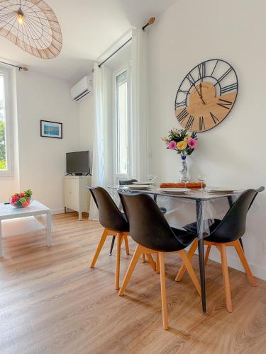 une salle à manger avec une table et une grande horloge murale dans l'établissement Le Margot By ApiRent #Climatisation #Wifi #Balcon, à Cannes