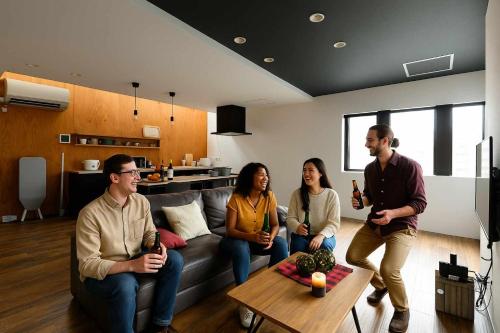 a group of people sitting on a couch in a living room at D plus one doors in Otaru