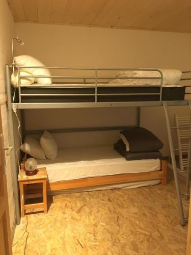 Ce lit se trouve dans un dortoir doté de 2 lits superposés et d'une lampe. dans l'établissement Cordon chalet appartement avec vue MontBlanc, à Cordon