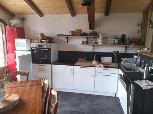 - une cuisine avec des appareils électroménagers blancs et une table dans l'établissement Cordon chalet appartement avec vue MontBlanc, à Cordon