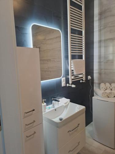 un bagno con un lavandino bianco e uno specchio di JBHotels Apartament Deluxe Hanza Tower a Stettino